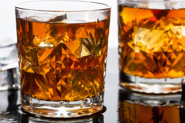 Whiskey in old fashioned glasses with ice, close up