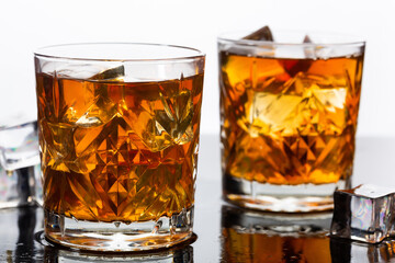 Whiskey in old fashioned glasses with ice, close up