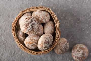 fresh delicious gingerbread cookies in a wicker basket on a gray background, close up