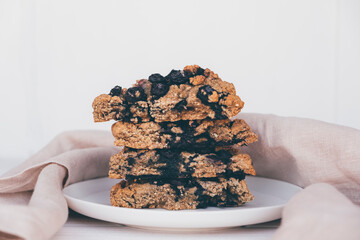 Homemade oatmeal scones with berries stacked on white plate. Vegan sweet baked food. Gluten free pastry.