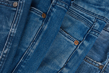 Fototapeta premium Stack of Various Shades Of Blue Jeans On White Background Denim jeans texture. Denim background texture for design. Canvas denim texture. Blue denim that can be used as background.