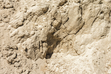 Vertical wall of a sand pit. As a natural background. Yellow sand.