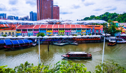 View of tourist wooden boat floating on Singapore river with downtown buildings in the background,