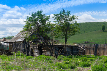 Old ruined uninhabited rustic wooden houses made of logs sunny day