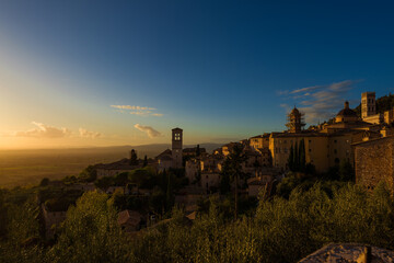 Assisi historic center ancient buildings and Umbria countryside at sunset