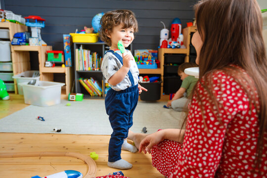 Mom plays with the children in the stylish nursery.