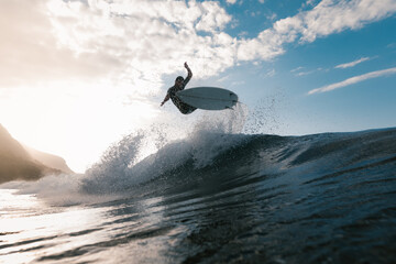 Unrecognizable athlete practicing surfing on ocean wave