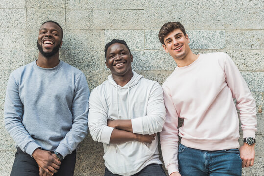 Content multiethnic friends in casual clothes on gray background