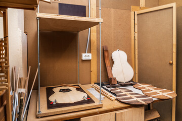 Guitar pieces on wooden table in workshop