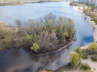 Lake shore in the park in spring. Aerial drone view.