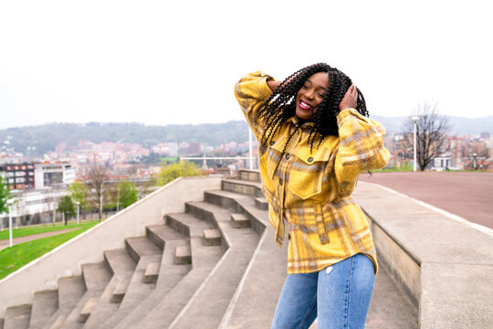 Energetic black woman dancing on concrete border