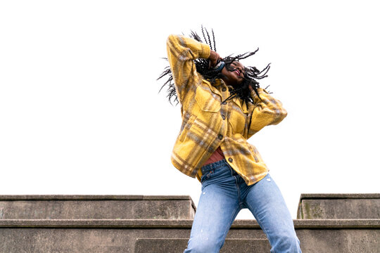 Energetic black woman dancing on concrete border