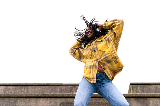 Energetic black woman dancing on concrete border