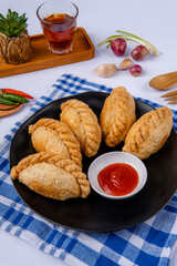 Curry puff or Pastel goreng. it is a small pie consisting of curry with chicken and potatoes in a deep-fried or baked pastry shell. The curry is quite thick to prevent it from oozing out of the snack