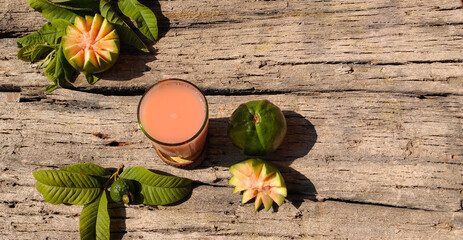 Obraz na płótnie Canvas Closeup of Vitamin C rich Fresh Pink Guava juice in a wooden base background with selective focus and copy space for inscription. Summer refreshment. Fresh juice.