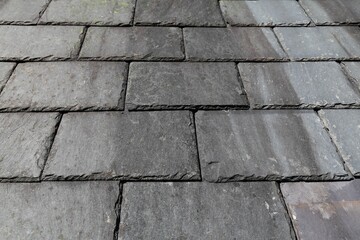 A close up view of some traditional slate tiles on a roof in Wales, UK.