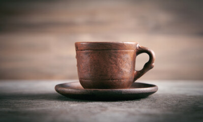 Clay cup of coffee on a table.