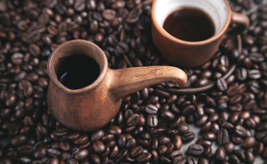 Clay coffee cup and pot on coffee beans.