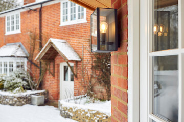 Close Up Of Exterior Lamp Outside Snow Covered House In Winter