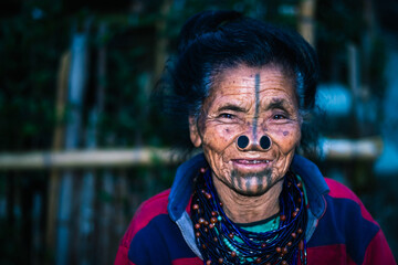 apatani tribal women facial expression with her traditional nose lobes and blurred background image...