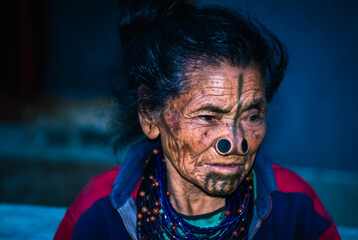 Fototapeta na wymiar apatani tribal women facial expression with her traditional nose lobes and blurred background