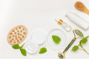 Natural cosmetics with nettle leaves. Top view. Cream, serum, bottle lotion.