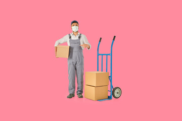 Delivery and transporter man is holding cardboard box and blue hand truck colorful background.