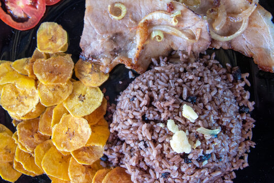 Cuban traditional cuisine, pork steak, banana fries, and congri rice
