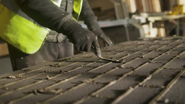 Construction worker grouting in between tiles, Mansfield, Nottinghamshire, UK