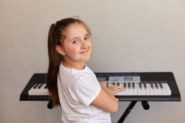 Portrait of cute girl playing electric piano