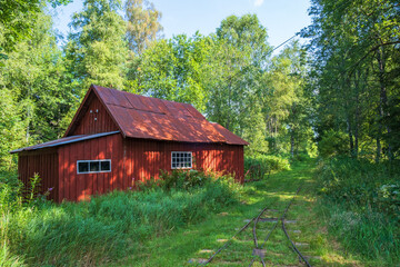 Old red shed at a light railway in the forest
