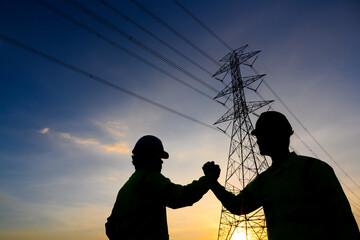 The silhouette of an electrical engineer with a worker Talk to each other and shake hands to agree...