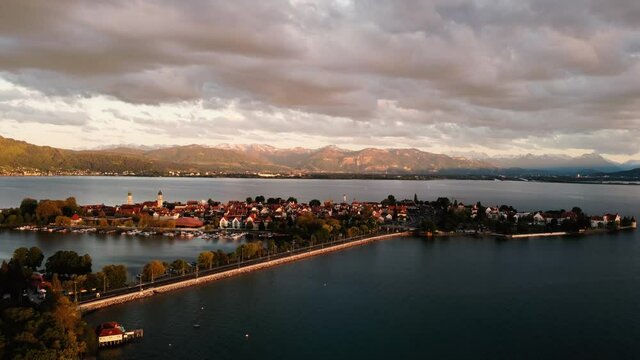 Die Inselstadt Lindau von Nordwesten bei Abendlicht im &Uuml;berblick gegen Pf&auml;nderr&uuml;cken, Bregenz im Hintergrund und Berge mit sonnenbeleuchtetem Abendhimmel; Drohnenvideo