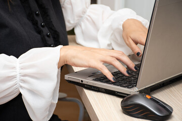 Young woman working on computer at table in office, closeup. Banner design. Elegant outfit