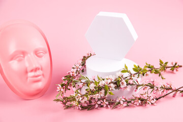 Minimal scene with geometric shapes and a pink mask on a pink background for advertising cosmetics. Horizontal orientation