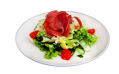 Salad with ham and vegetables lettuce, cabbage, tomato. Jamon jerky on a white plate isolated on a white background. Meat with vegetables