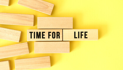 TIME FOR LIFE text written on a wooden blocks on a yellow background.