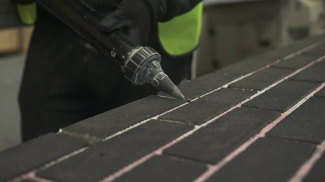 Construction worker grouting in between tiles, Mansfield, Nottinghamshire, UK