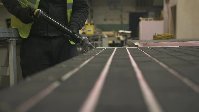 Construction worker grouting in between tiles, Mansfield, Nottinghamshire, UK
