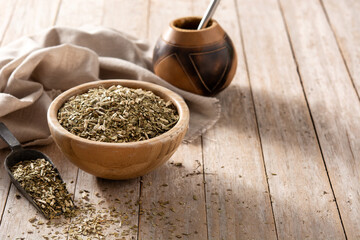 Traditional yerba mate tea in bowl on wooden table. typical Argentine drink. Copy space
