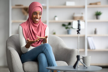 Modern Blogging Concept. Black Muslim Lady In Hijab Recording Video At Home