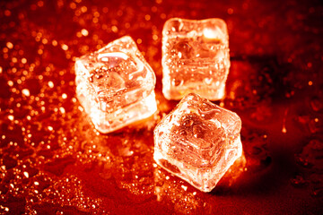 Red ice cubes reflection on black table background.