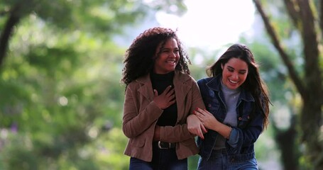 Two happy girlfriends laughing together in conversation