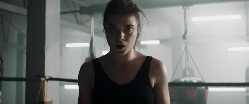 HANDHELD Portrait of Caucasian female boxer posing and looking into camera after the fight. Shot with 2x anamorphic lens