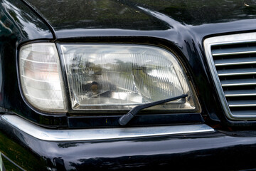 Fototapeta na wymiar Closeup of headlights with windshield wipers of old cars