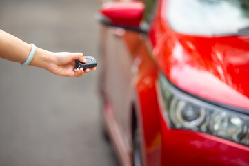Car Auto Alarm and Remote Central Lock Car Keys in Driver Hand Sending Signal to the Vehicle