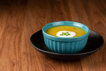Bowl with pumpkin soup on the table.