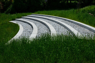 tribune in the park by a concrete staircase made of gray granite stones into an arch in the middle...