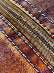 Close-up view of stiches and zipper of woman purse