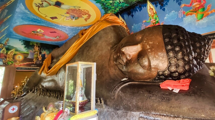 Obraz premium Huge stone statue of reclining buddha. Buddhist drawings and religious offerings. Phnom kulen national park. Siem Reap Province. Cambodia. South-East Asia